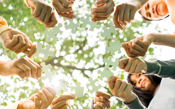 People holding puzzle pieces together